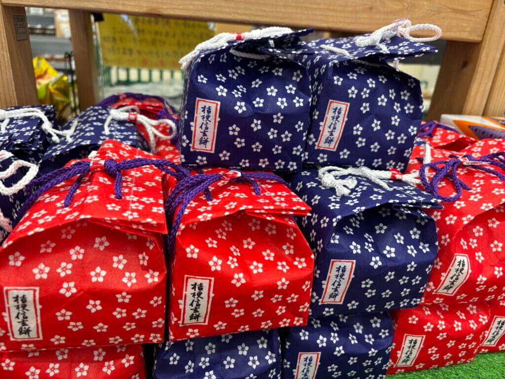 桔梗信玄餅の赤と紺の巾着包みが並ぶ様子 山梨の人気土産